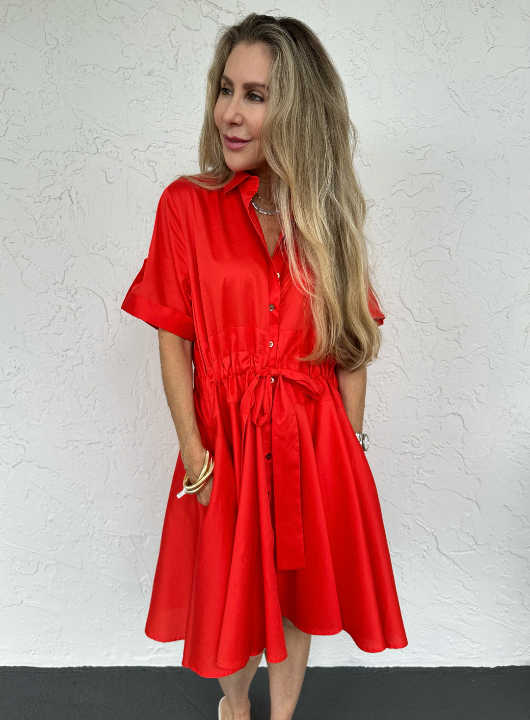 Harshman Meadow Drawstring Belt Dress in Poppy Red, made from 100% cotton featuring a spread collar, button front closure, short sleeves with roll-tab cuffs, drawstring waist, and high-low hem