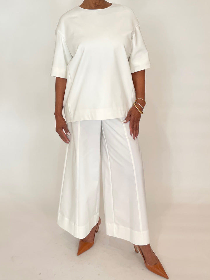 Simkhai Aude Short Sleeve Top in White paired with matching Simkhai Kallin Cropped Wide Leg Pants in White  available at Barbara Katz