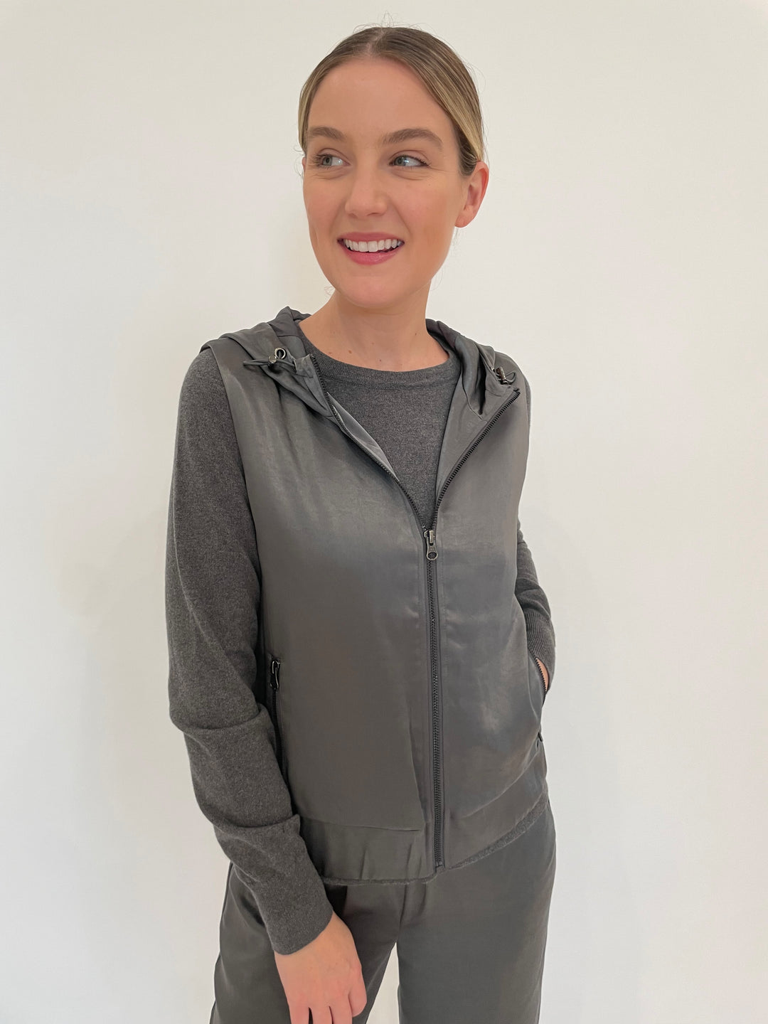 J Society Celeste Satin Hoodie Vest in Gunmetal with Jette Satin Pocket Sweatshirt underneath, paired with matching J Society Jesse Satin Pants in Gunmetal available at Barbara Katz