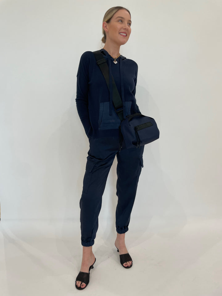 J Society Roxie Satin Pocket Hoodie in Navy paired with matching J Society Juno Satin Cargo Pants in Navy, Elizabeth Cole Jewelry Meira Necklace, Daniella Lehavi Bonnie Crossbody Bag in Navy - all available at Barbara Katz