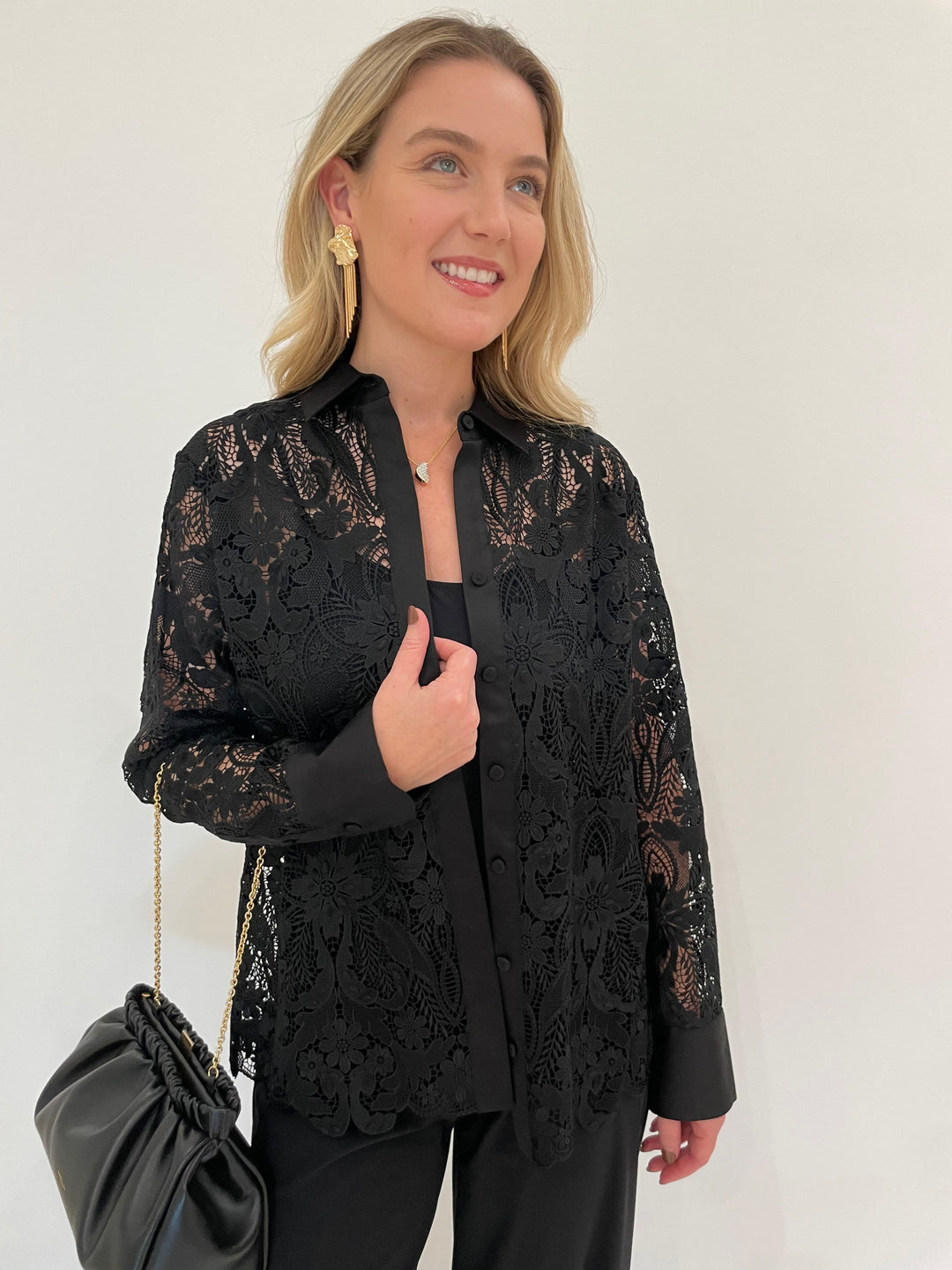 Hinson Wu Margot Long Sleeve Lace Shirt Jacket in Black paired with Raffaello Rossi 7/8 Pants in Black, BK Melanie Gold Hammered Organic & Fringe Earrings, DeMellier Miami Clutch in Black - all available at Barbara Katz