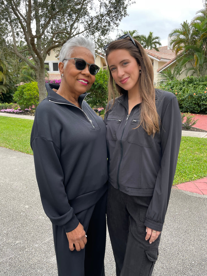 Elliott Lauren Comfort Zone Half-Zip Sweatshirt in Black paired with matching black sweatpants, Wearables Active Quinn Bomber Jacket in Black paired with XCVI Sunny Cargo Pants in Black available at Barbara Katz