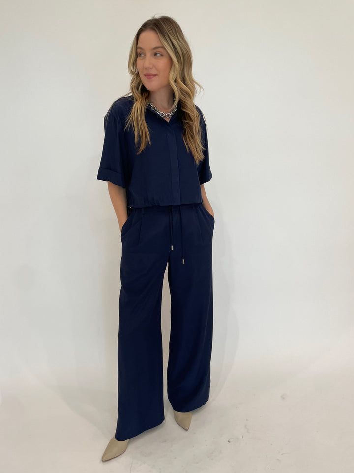 Simkhai Ryett Short Sleeve Cropped Shirt in Midnigh paired with matching Sydnie Pleated Pants in Midnight, Pono Barile Mini Bike Chain Necklace in Silver available at Barbara Katz