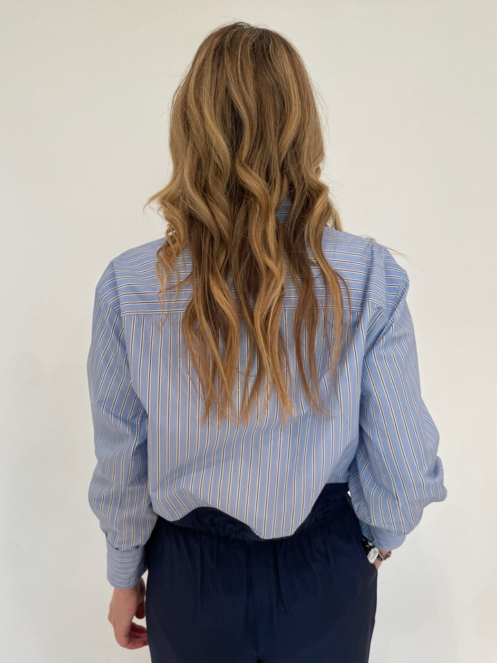 Simkhai Adryck Harbor Blue Stripe Shirt paired with SImkhai Sydnie Pleated Pants in Midnight available at Barbara Katz