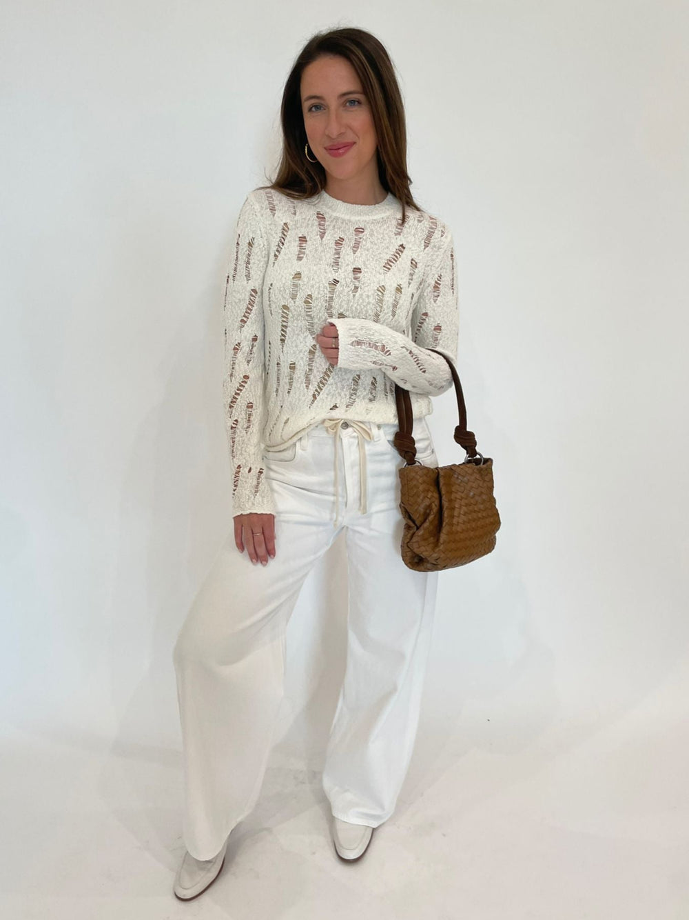 Autumn Cashmere Lucy Distressed Ladder Stitch Crew Sweater in Starch paired with Citizens of Humanity Brynn Drawstring Trousers in Tulip and Daniella Lehavi Bali Mini Knotted Bag in Caramel Woven available at Barbara Katz