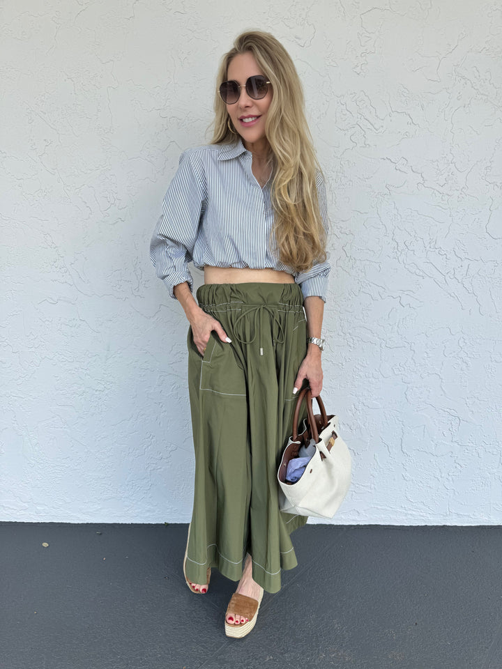 Model wearing Simkhai Tona Midi Skirt in Army Green paired with Mother's The Poppy Top with long sleeves