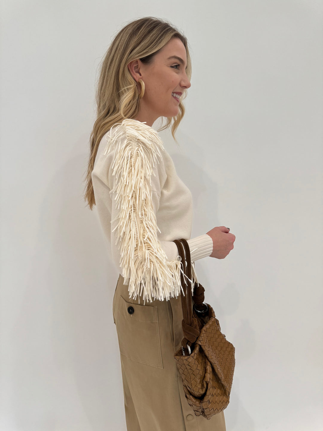 D.Exterior Fringe Sleeve Crew Sweater in Latte shown with Daniella Lehavi Bali Knotted Bag in Caramel Woven available at Barbara Katz