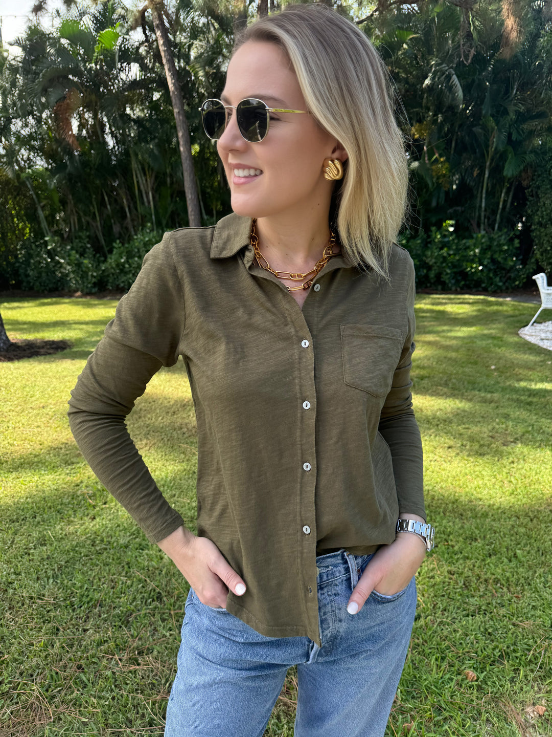 An olive green Elliott Lauren Button Front Shirt made of 100% cotton, with long sleeves, a button-down front, chest pocket, and a collar. Ideal for formal or casual wear. #elliottlauren #shirt #longsleeves