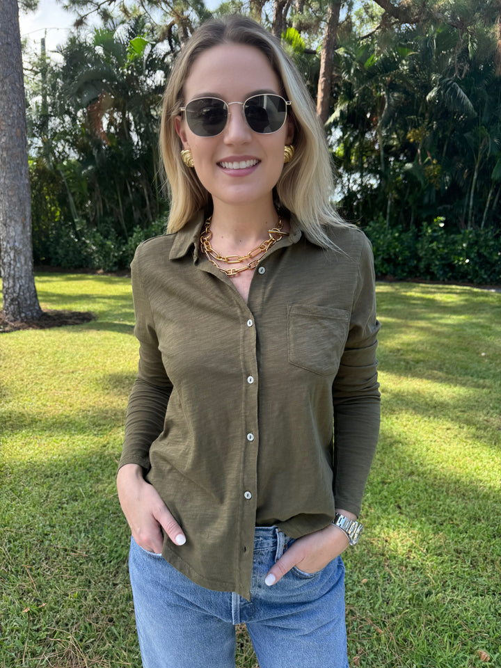 An olive green Elliott Lauren Button Front Shirt made of 100% cotton, with long sleeves, a button-down front, chest pocket, and a collar. Ideal for formal or casual wear. #elliottlauren #shirt #longsleeves