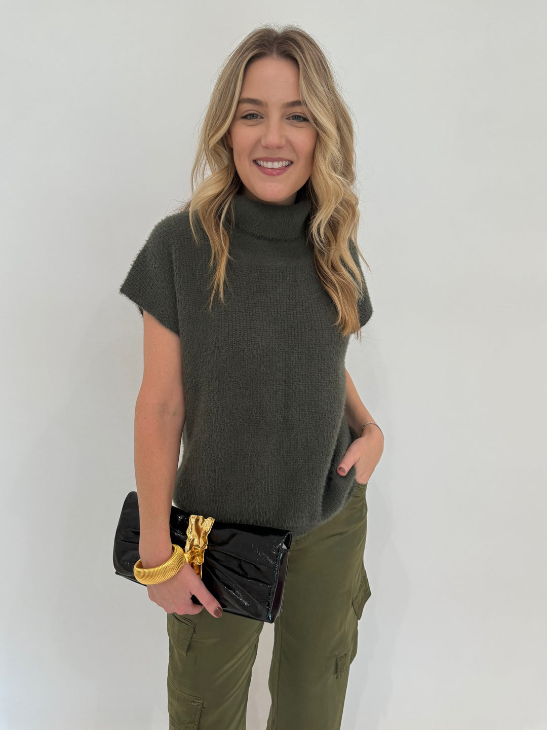 Melissa Nepton Jack Turtleneck Sweater in Winter Moss paired with Marrakech Zendaya Silky Cargo Pants in Pine, BK Gold Cobra Bracelet, and Alexis Bittar Gold Ribbon Convertible Shoulder Bag in Black - all available at Barbara Katz