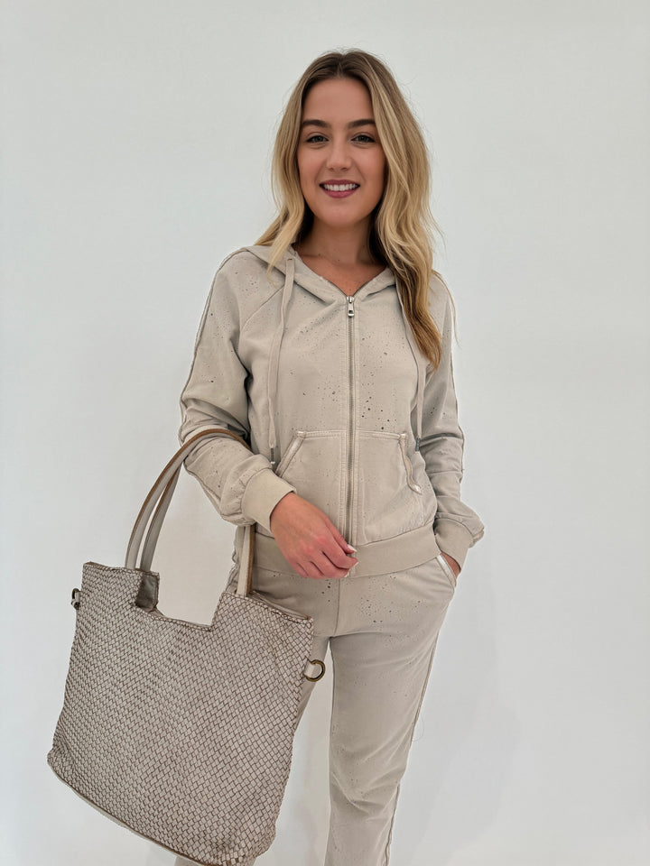 BK Sandy Distressed Zip Hoodie in Beige paired with Mandy Distressed Jogger and Intrecciato Tote Bag, all available at Barbara Katz