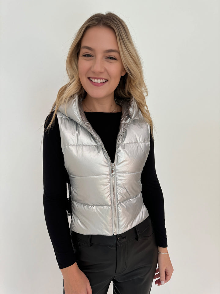 Adroit Atelier Lola Quilted Full Zip Vest in Silver with AMB Black Solid Raw Edge High Neck Second Skin Top underneath, paired with Peace of Cloth Black Faux Leather Slim Jeans, all available at Barbara Katz