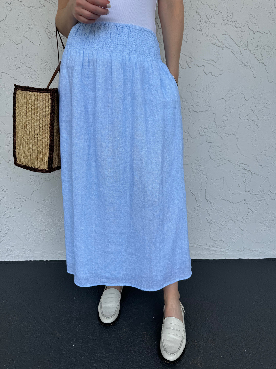 Kerri Rosenthal Martin Jayney Skirt in Windsurfer, light blue skirt made from 100% linen featuring pull-on style, midi length, smocked elastic waistband, heart embroidery on the back hip, and side slits