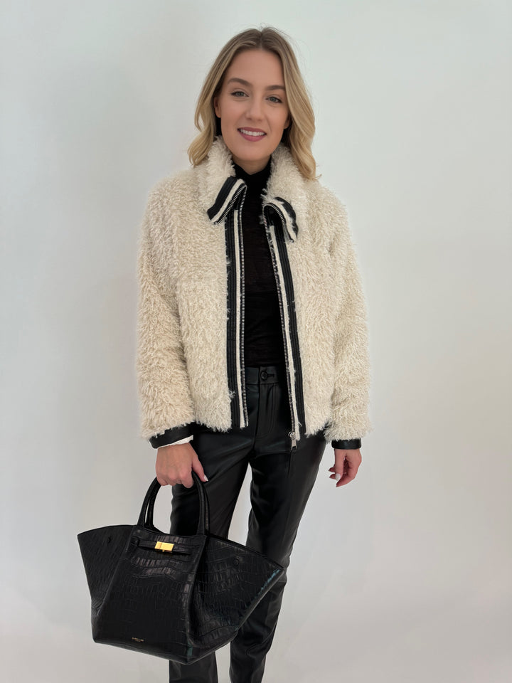 Adroit Atelier Carrie Short Mongolian Faux Fur Coat in Ivory paired with Peace of Cloth Black Faux Leather Slim Jeans, bag DeMellier The New York Tote in Black Croc Effect, all available at Barbara Katz