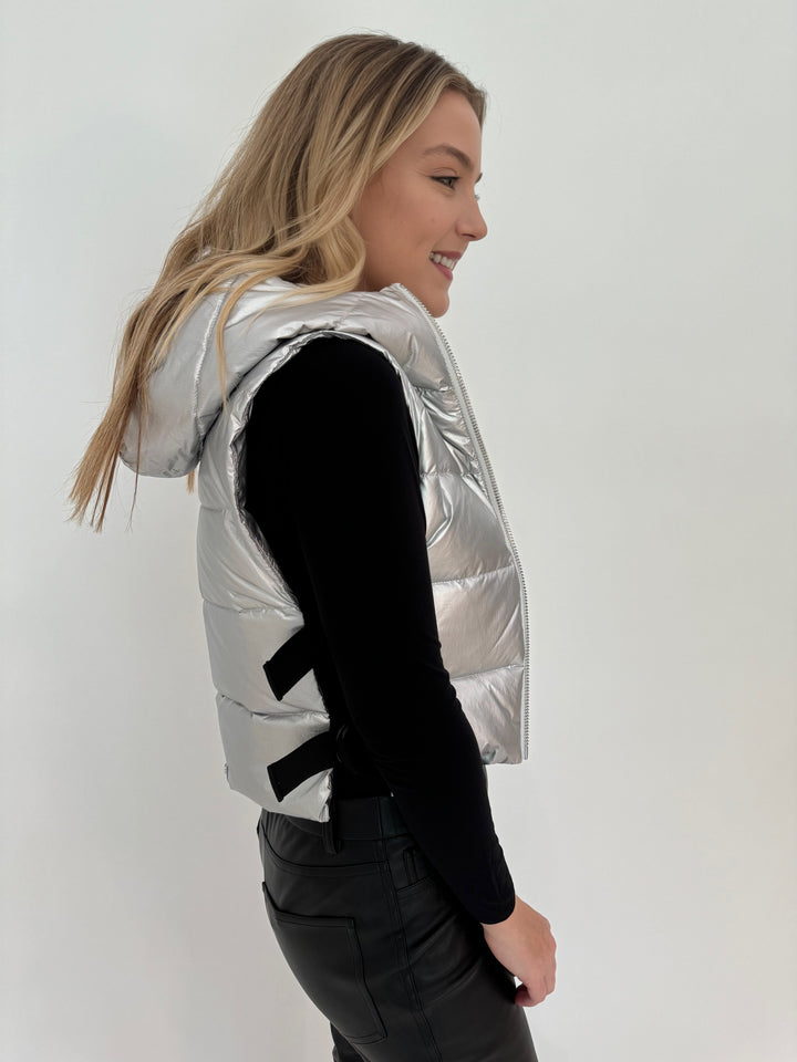 Adroit Atelier Lola Quilted Full Zip Vest in Silver with AMB Black Solid Raw Edge High Neck Second Skin Top underneath, paired with Peace of Cloth Black Faux Leather Slim Jeans, all available at Barbara Katz