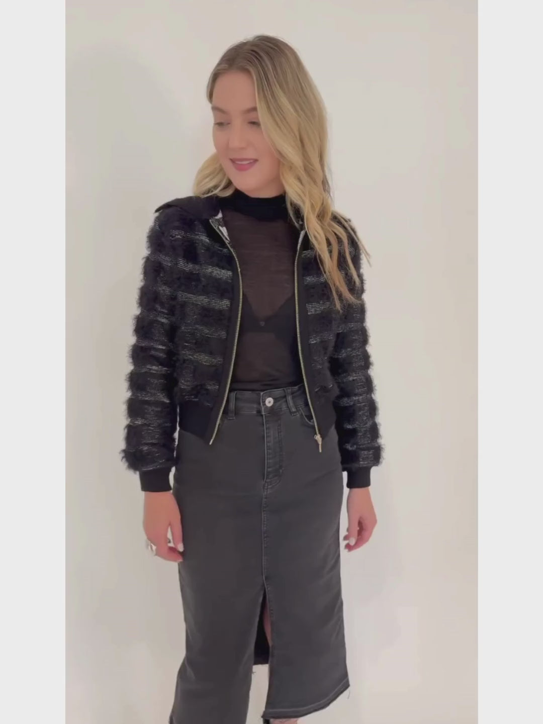 Maria Pavan Ellie Fringe Check Zip Up Sweater in Black/White with Aldomartins Black Norin Top underneath, paired with Elliott Lauren Black Jean Midi Skirt, all available at Barbara Katz