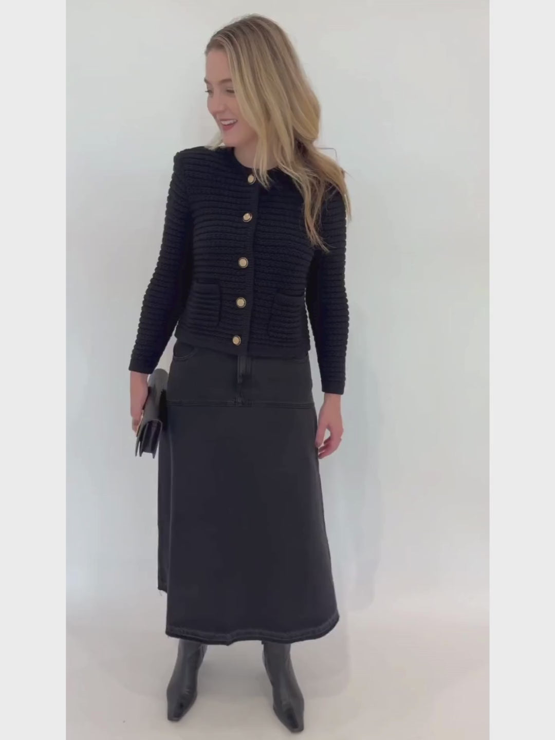 Ba&sh Gaspard Knit Cardigan in Noir paired with Volentia Denim Midi Skirt in Blackstone, Lizzie Fortunato Midnight Masquerade Earrings, Alexis Bittar Twisted Gold Side Handle Clutch Bag in Black available at Barbara Katz