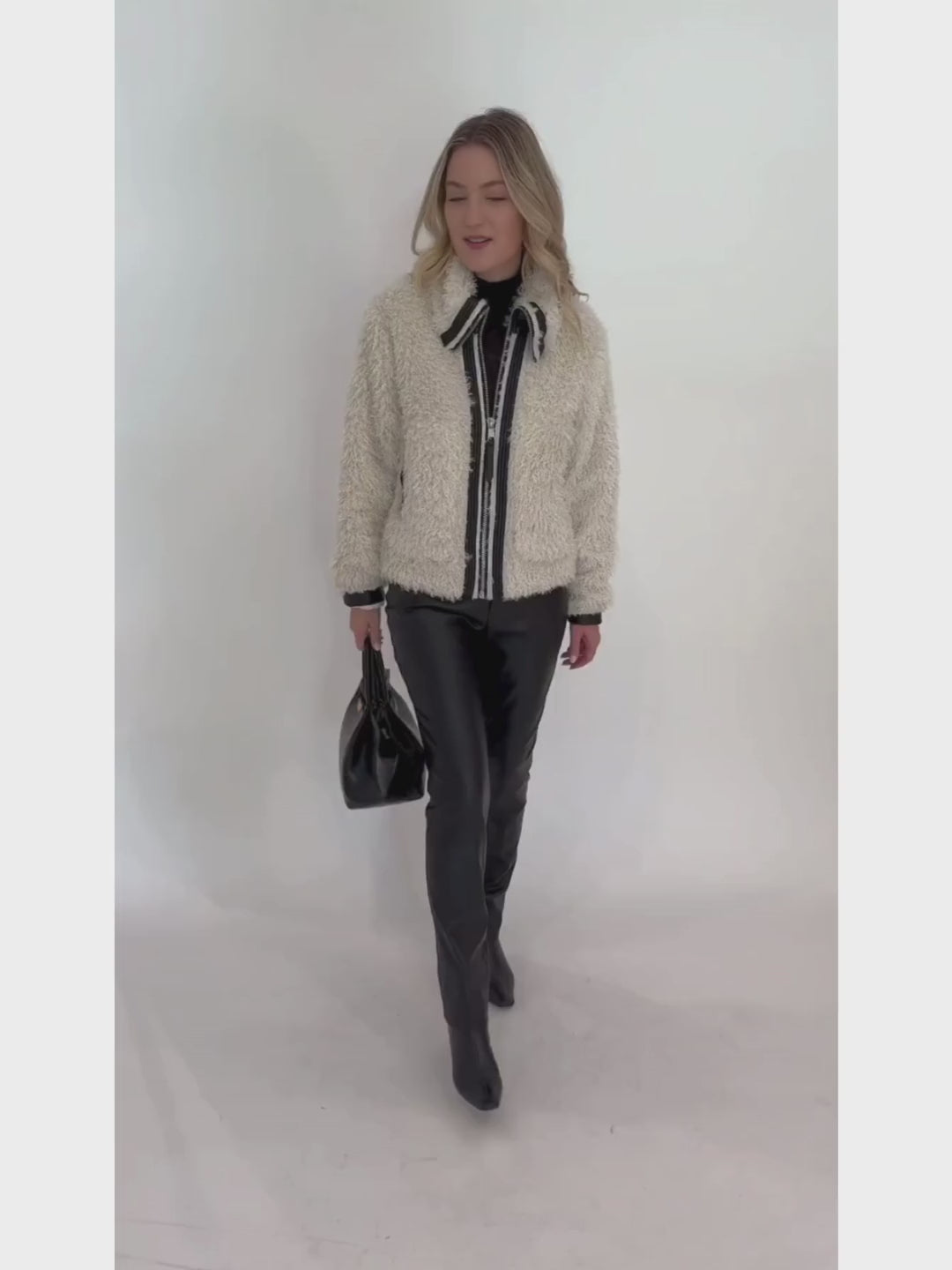 Adroit Atelier Carrie Short Mongolian Faux Fur Coat in Ivory paired with Peace of Cloth Black Jilian Faux Leather Slim Jeans, bag DeMellier The New York Tote in Black Croc Effect, all available at Barbara Katz